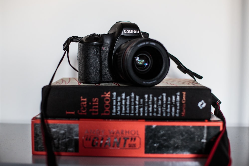 black Canon camera on top of books
