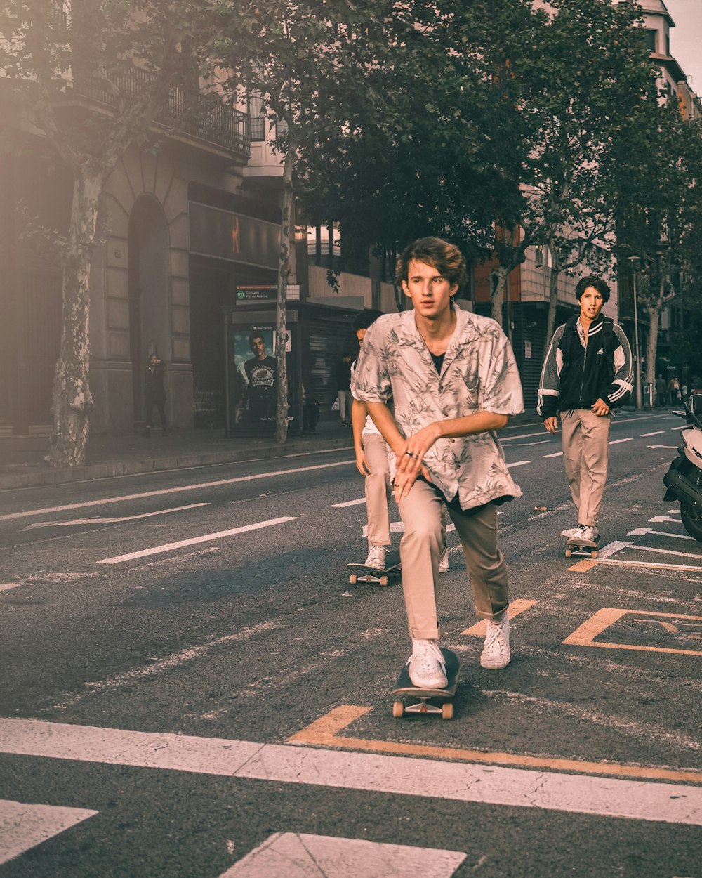three kids skateboarding on road