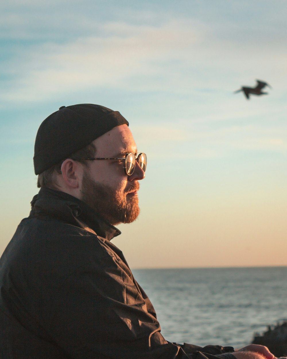 man wearing black knit cap overlooking on sea