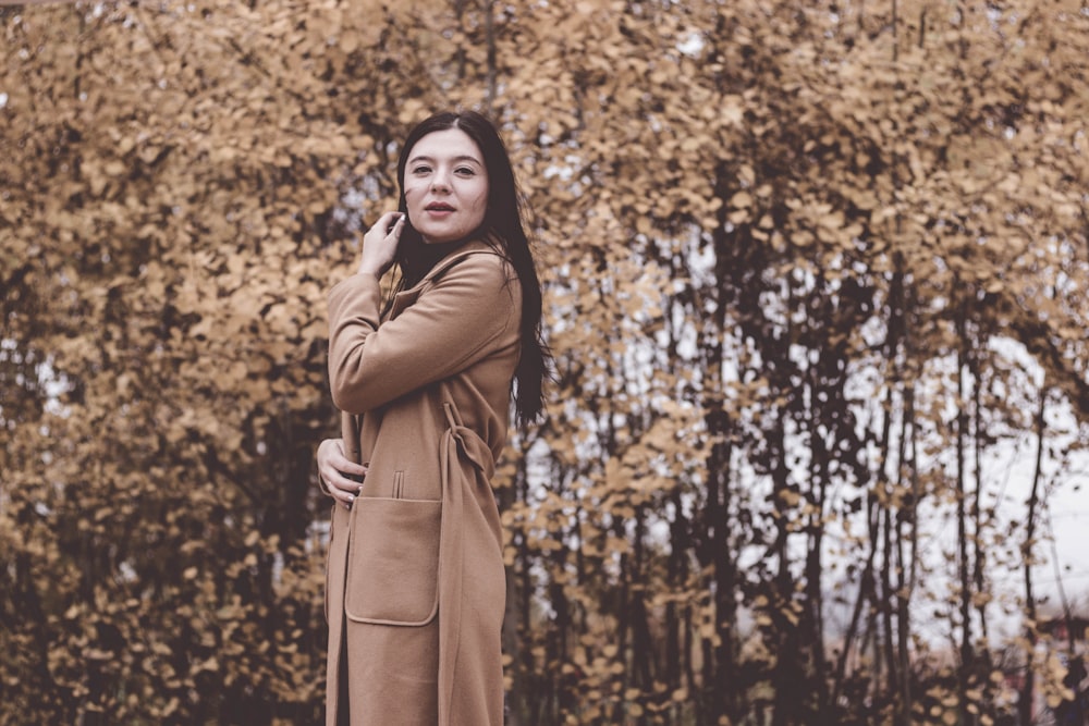 woman standing near brown tree