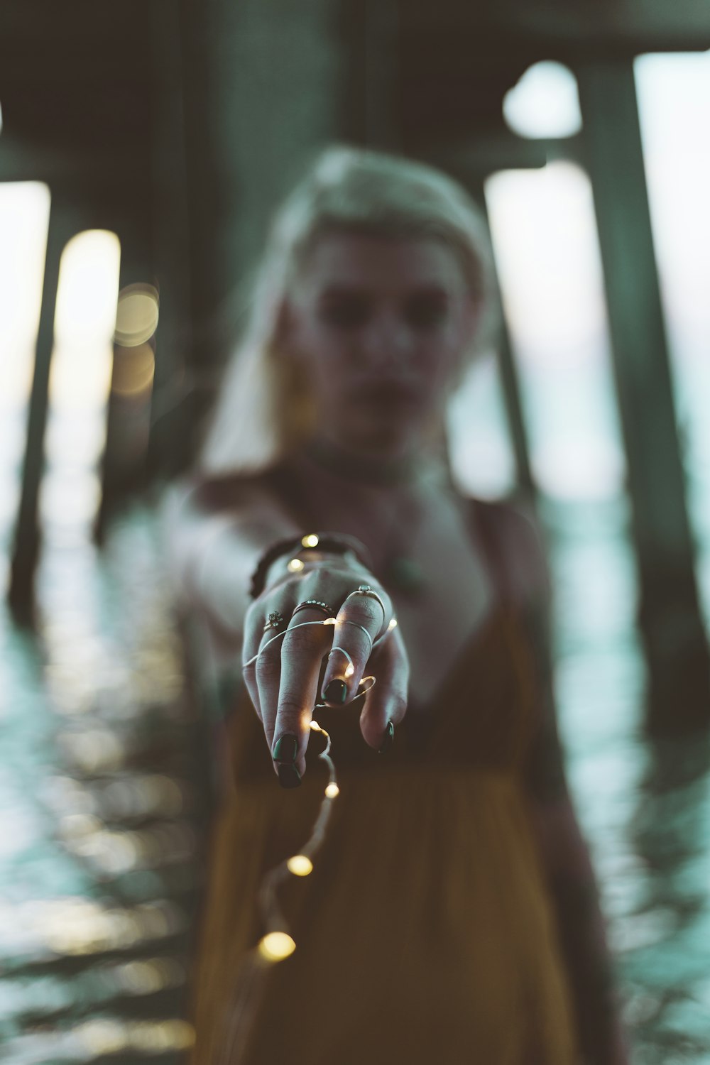 woman in brown dress with string lights wrapped on her hand