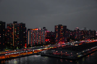 A sleek, modern Osaka cityscape at dusk highlighting luxury apartments with warm interior lights glowing.