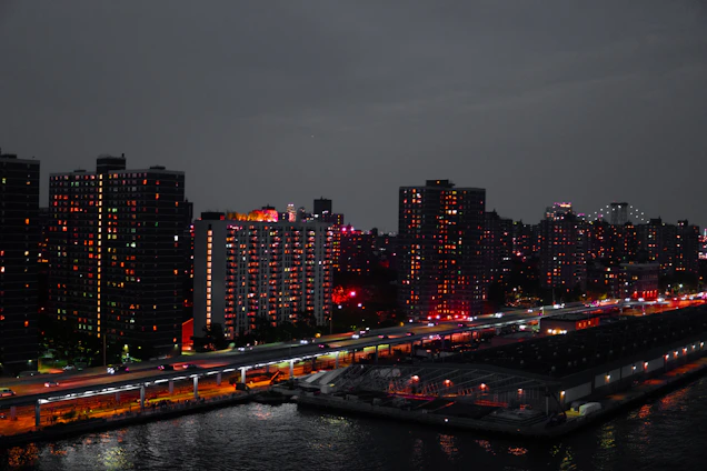 A sleek, modern Osaka cityscape at dusk highlighting luxury apartments with warm interior lights glowing.
