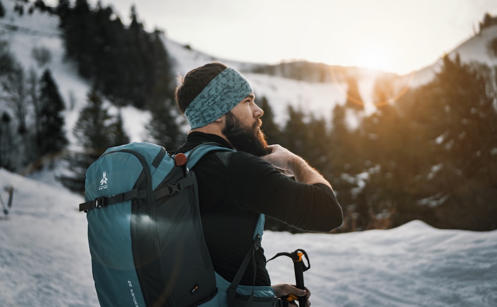 man holding his bear on snow field during daytime