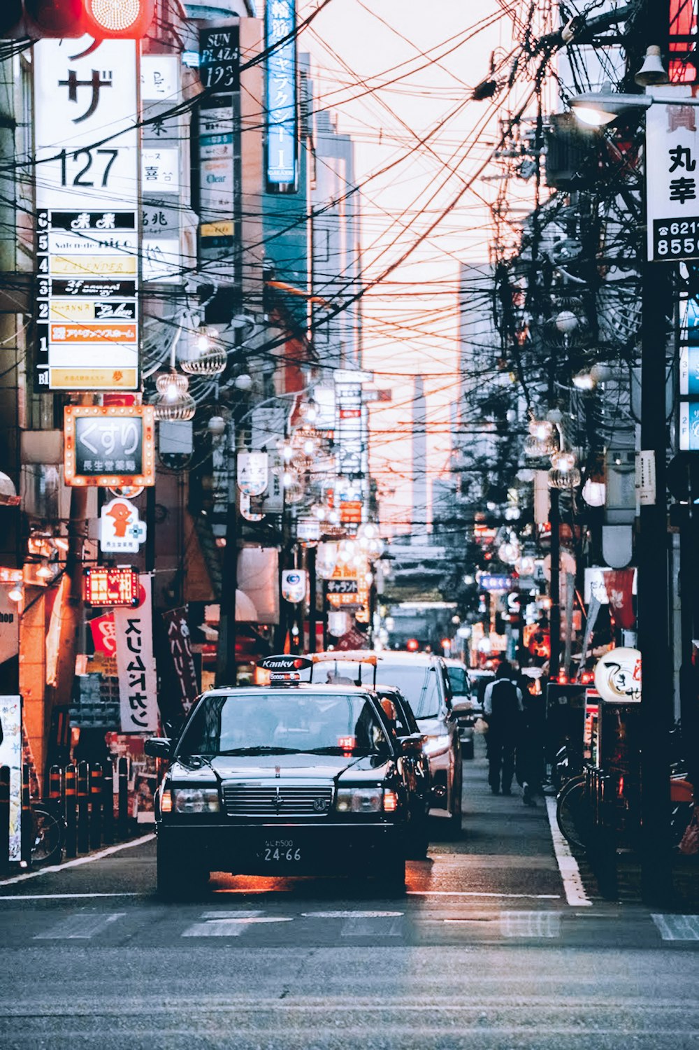 cars passing by commercial buildings during daytime