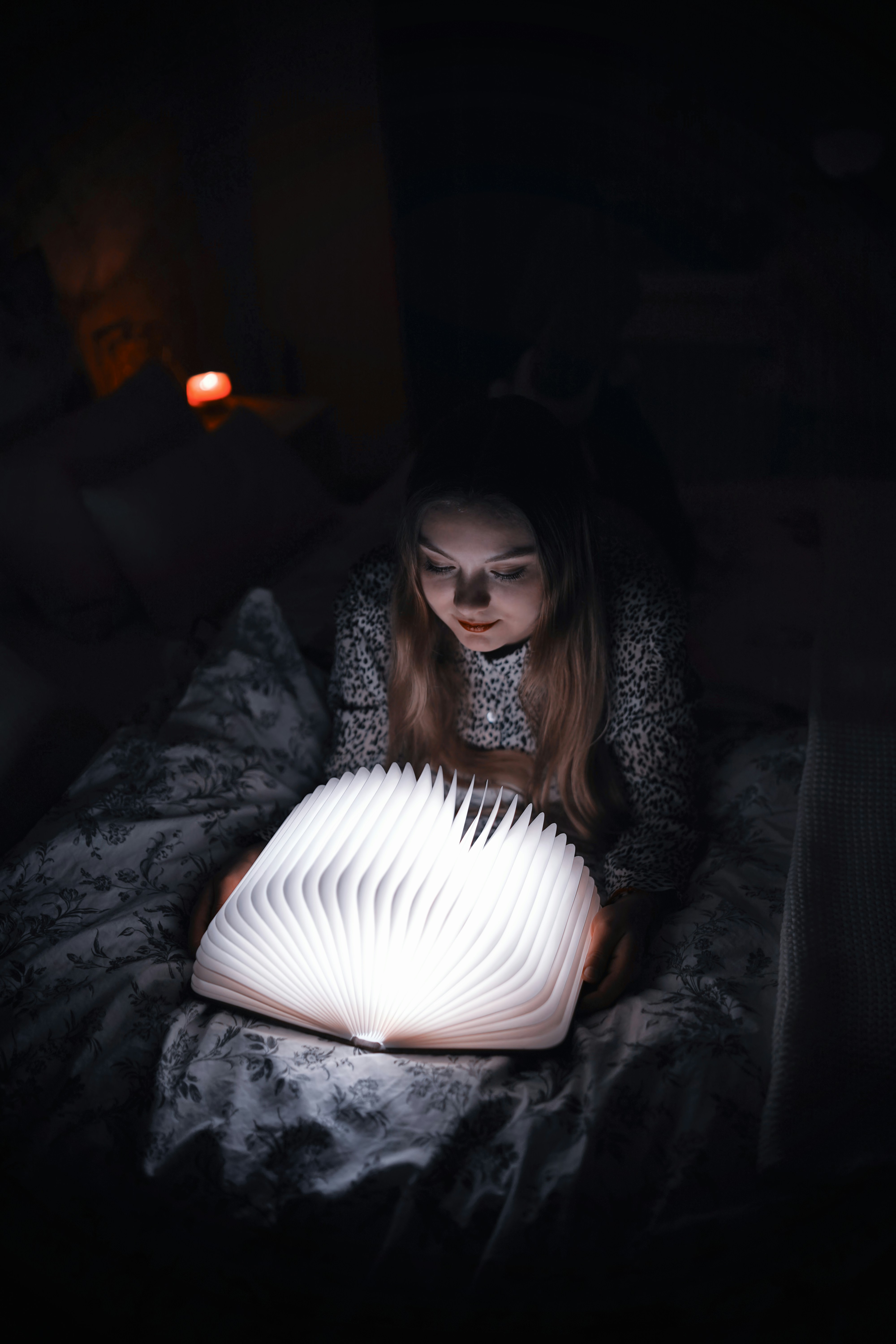 woman reading book on bed