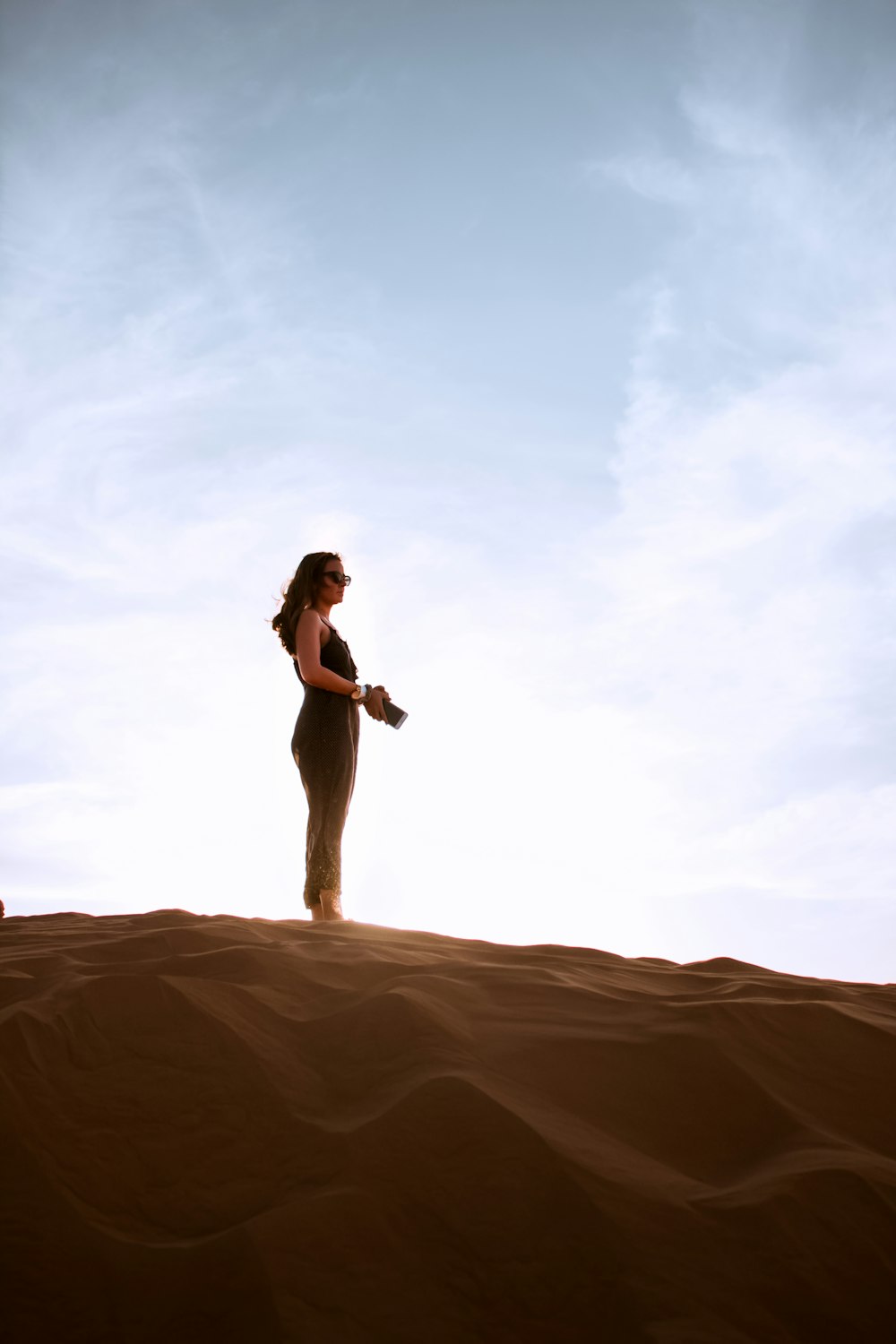 Mulher em pé na duna de areia