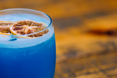 A close-up shot of a vibrant, freshly prepared cocktail with condensation on the glass.
