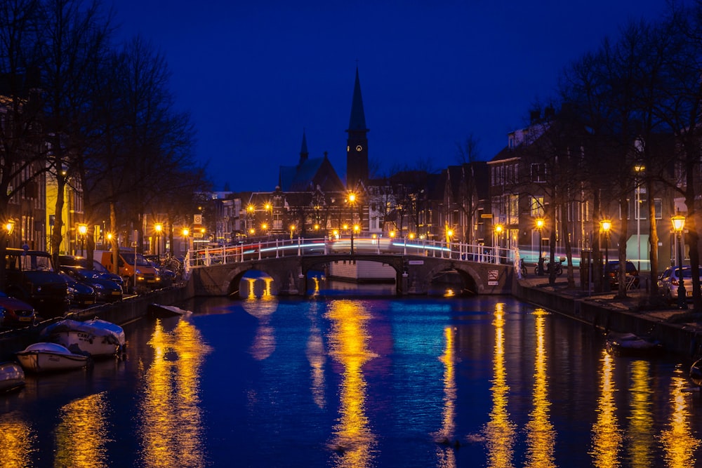 Ponte sul fiume calmo con lampioni illuminati durante la notte
