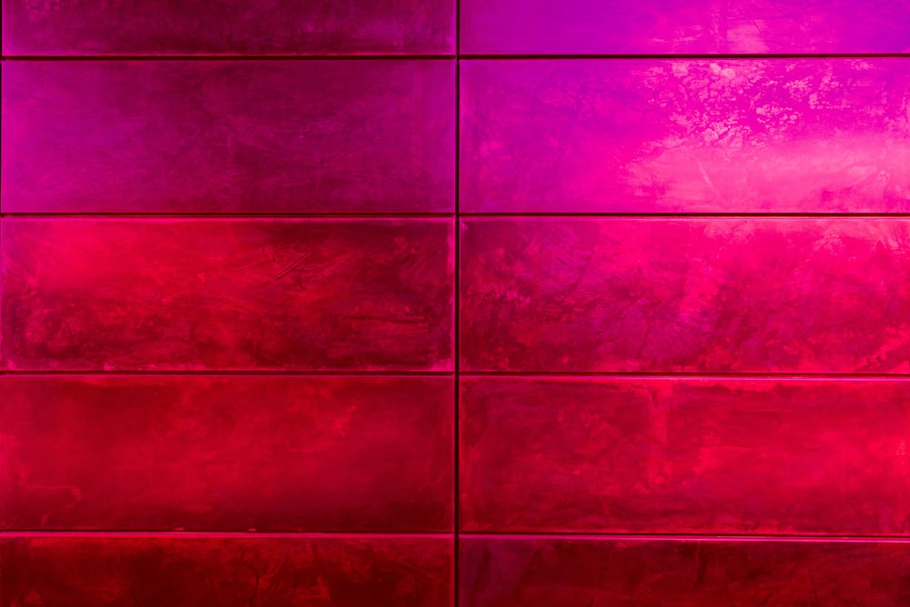 un muro di piastrelle rosse con un vaso rosso sopra di esso