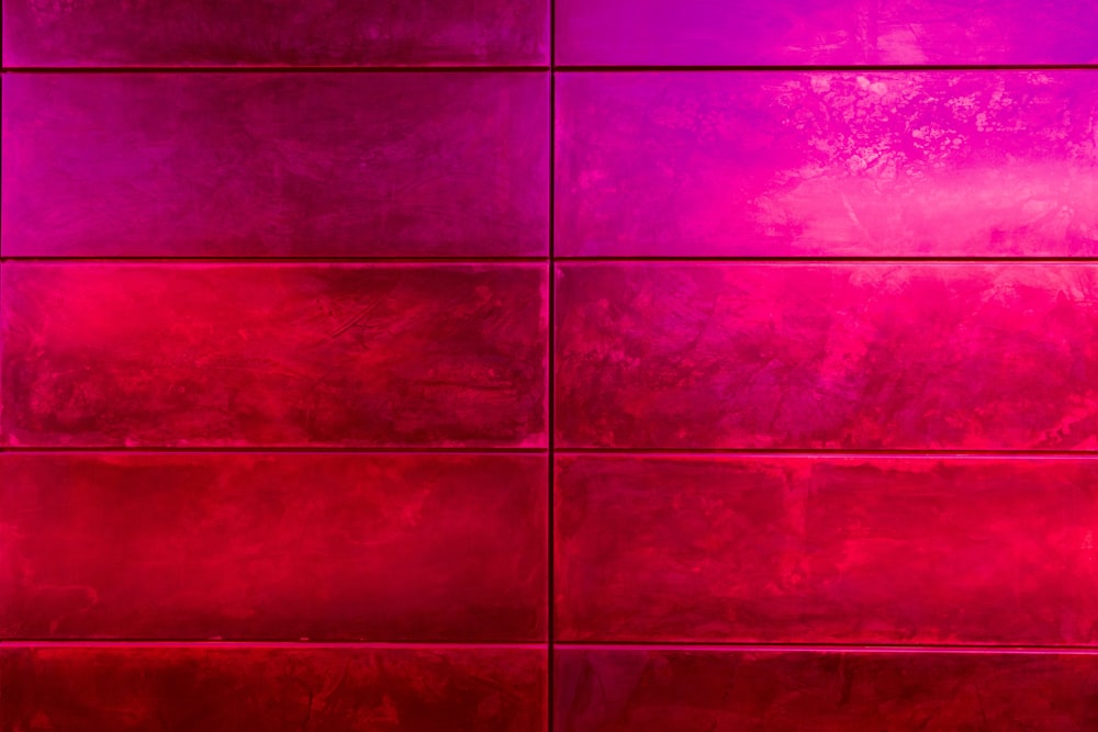 a red tiled wall with a red vase on top of it