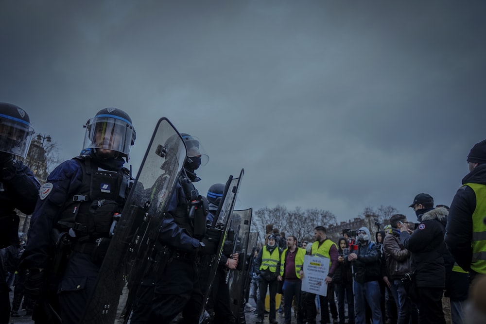 anti-riot police near line of people under gray skies