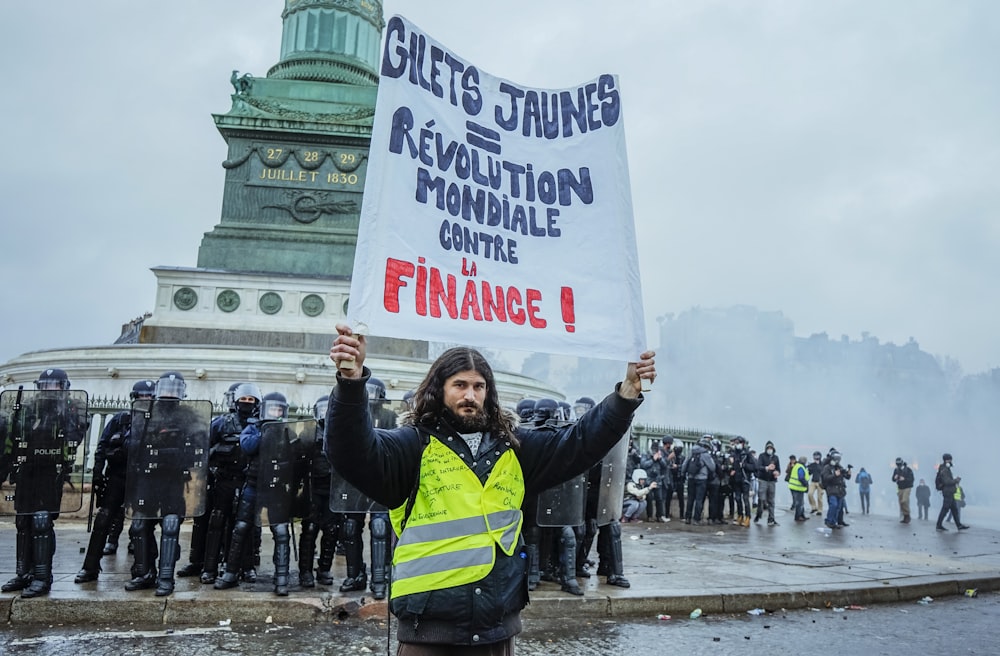 homme soulevant du papier blanc avec du texte sous le ciel blanc