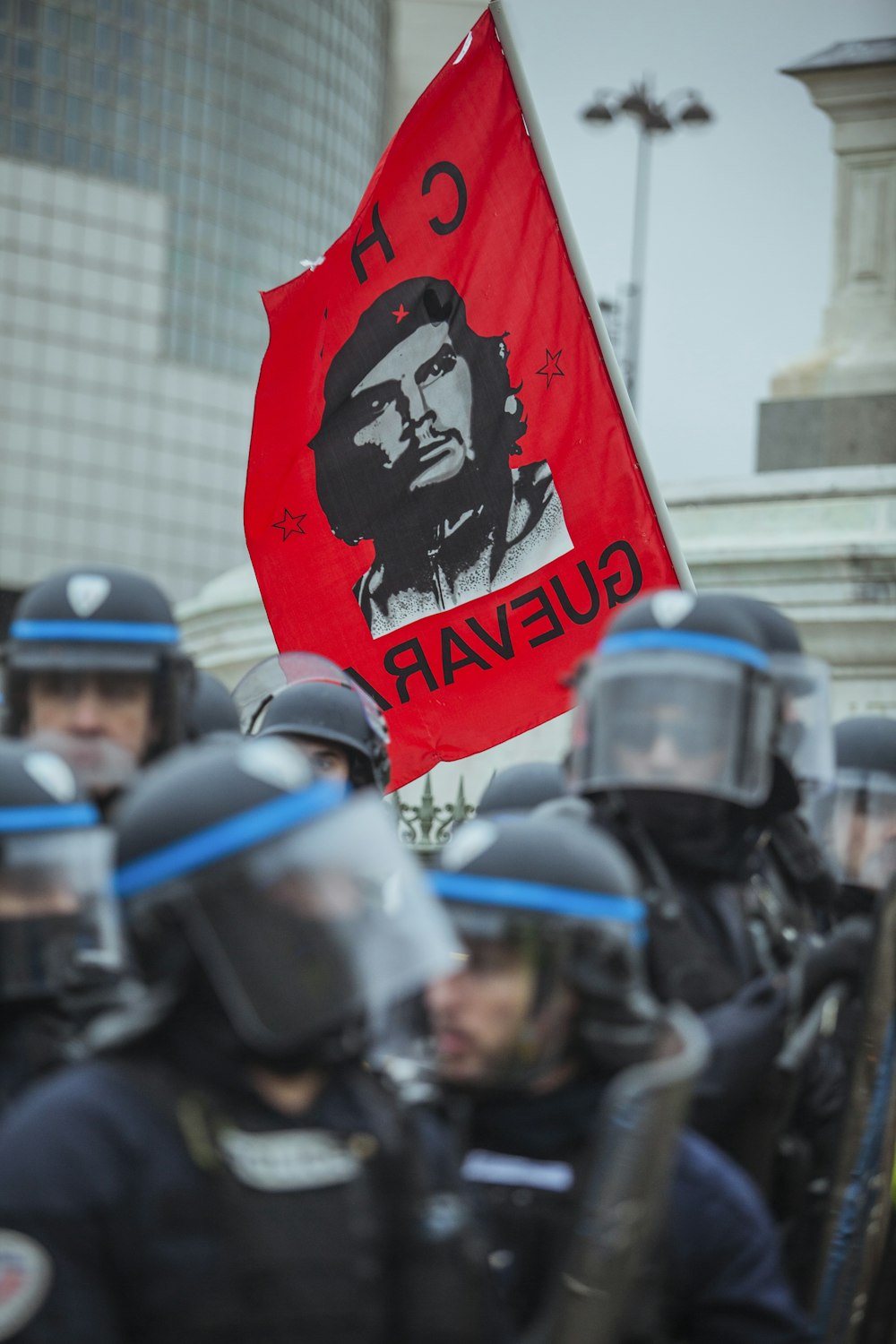 bandiera rossa di Che Guevara vicino a un gruppo di poliziotti durante il giorno
