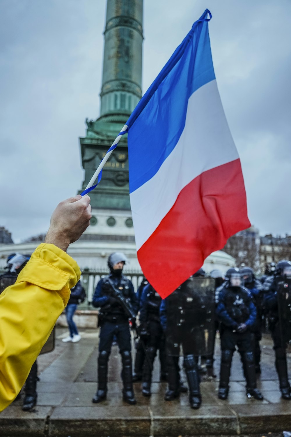 person waving flag near the soldiers