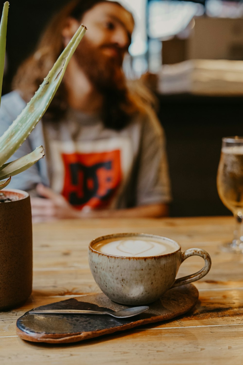 brown ceramic teacup filled with coffee on table