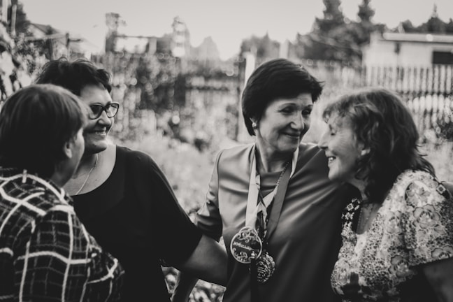 A warm group of women sharing smiles during a community gathering outdoors