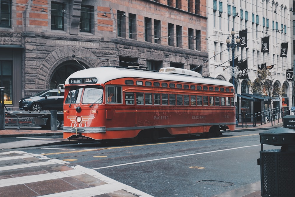 red bus beside concrete building