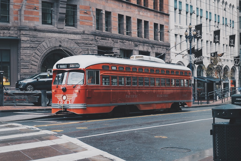 コンクリートの建物の横の赤いバス