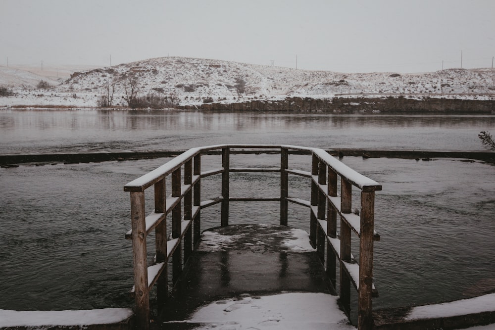 Muelles de madera marrón cubiertos de nieve durante el día