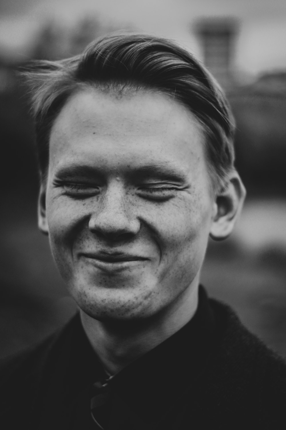 Foto en escala de grises de un hombre sonriente