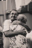 A couple wearing elegant anniversary t-shirts, holding hands and smiling warmly.
