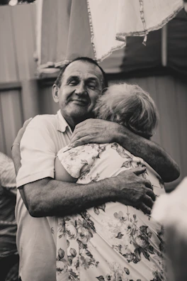 A couple wearing elegant anniversary t-shirts, holding hands and smiling warmly.