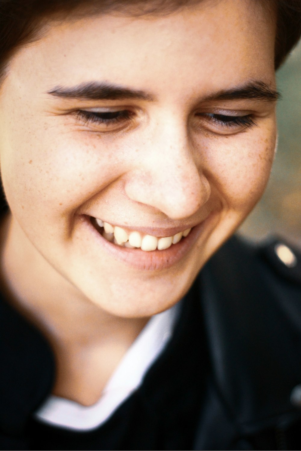 Mujer sonriente con camisa de cuello redondo en blanco y negro