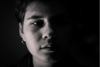 Monochrome fashion portrait highlighted by stark lighting and shadow play.