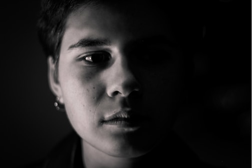 Monochrome fashion portrait highlighted by stark lighting and shadow play.