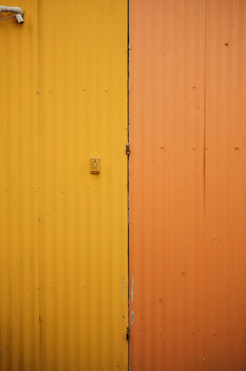 a yellow and a orange wall with pipes
