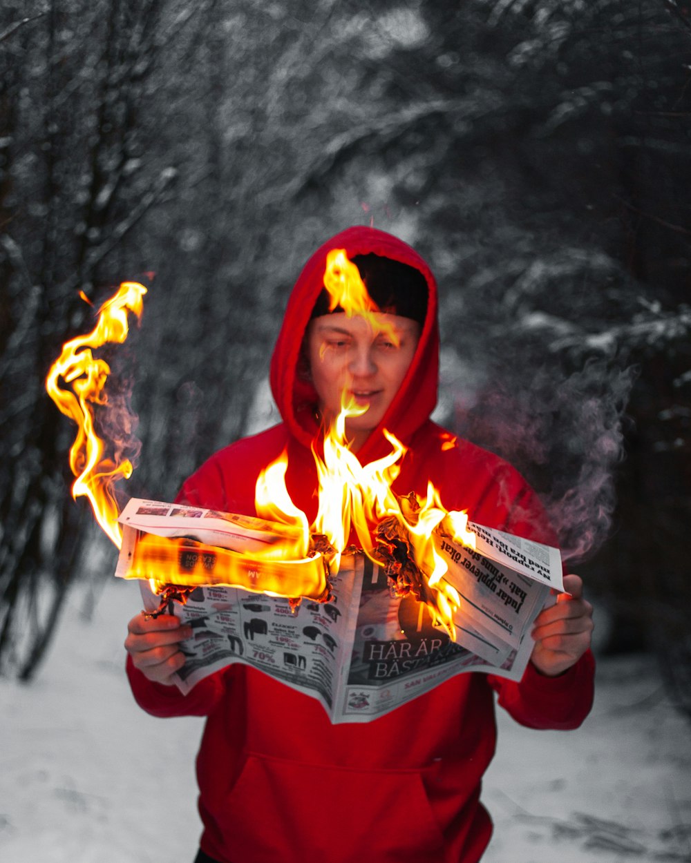 man standing while holding burning paper