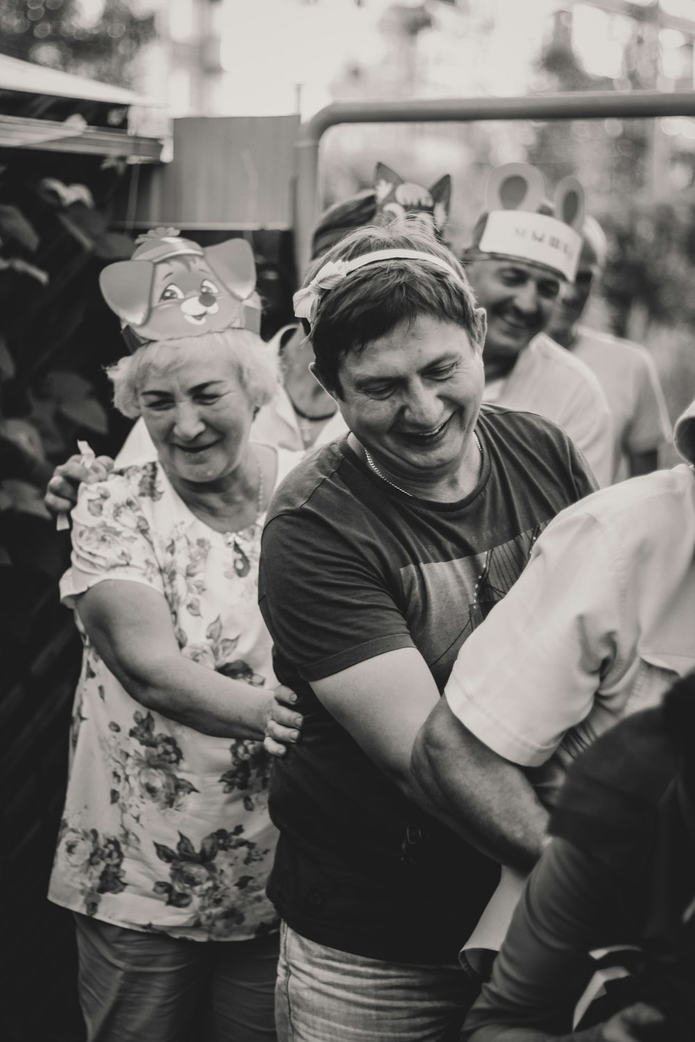 smiling people standing in line greyscale photography