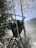 A wooden hunting stand situated among birch trees covered with frost, offering a view of the misty landscape and blue sky beyond.
