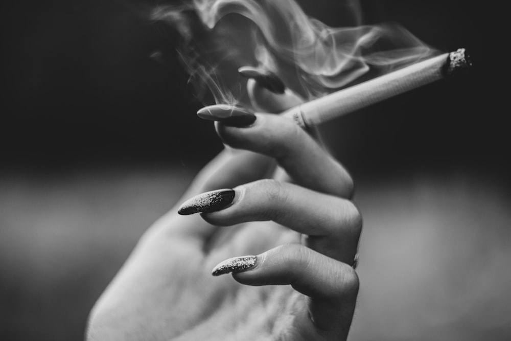 gray scale photo of woman holding cigarette