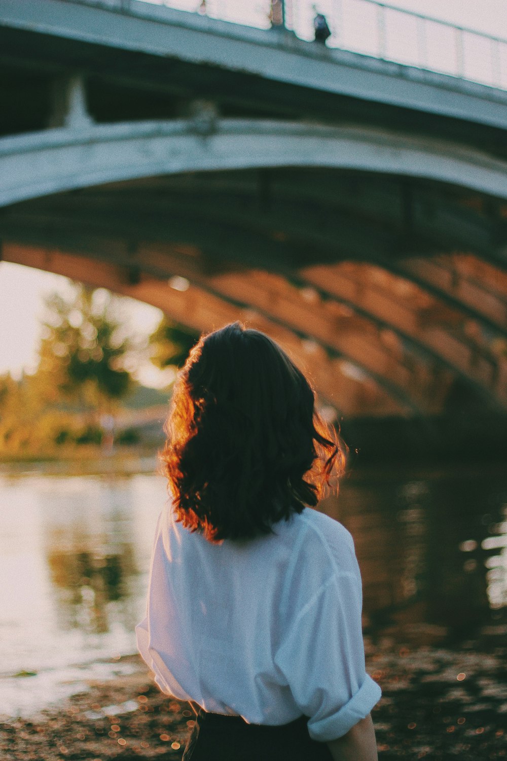 woman standing beside river looking up