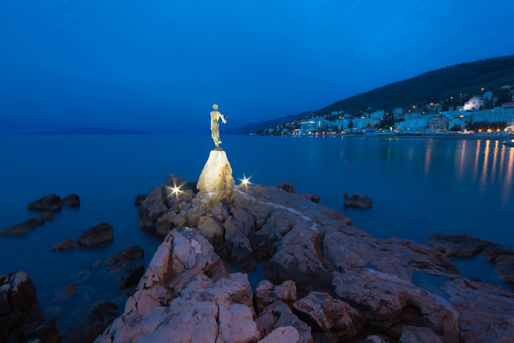 human standing statue near the city during daytime