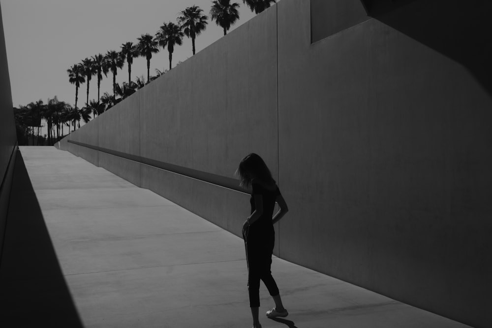 woman standing beside concrete wall