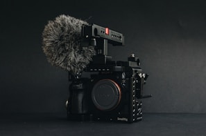 Close-up of a professional voice recorder setup on a film set with boom microphones in the background