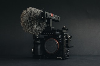 Close-up of a professional voice recorder setup on a film set with boom microphones in the background