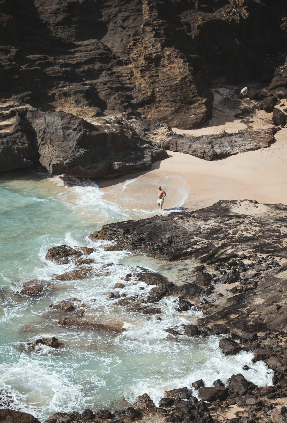 man standing on shore near rocks