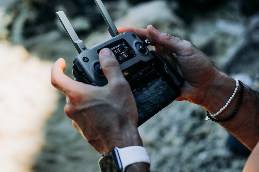 person holding black drone controller