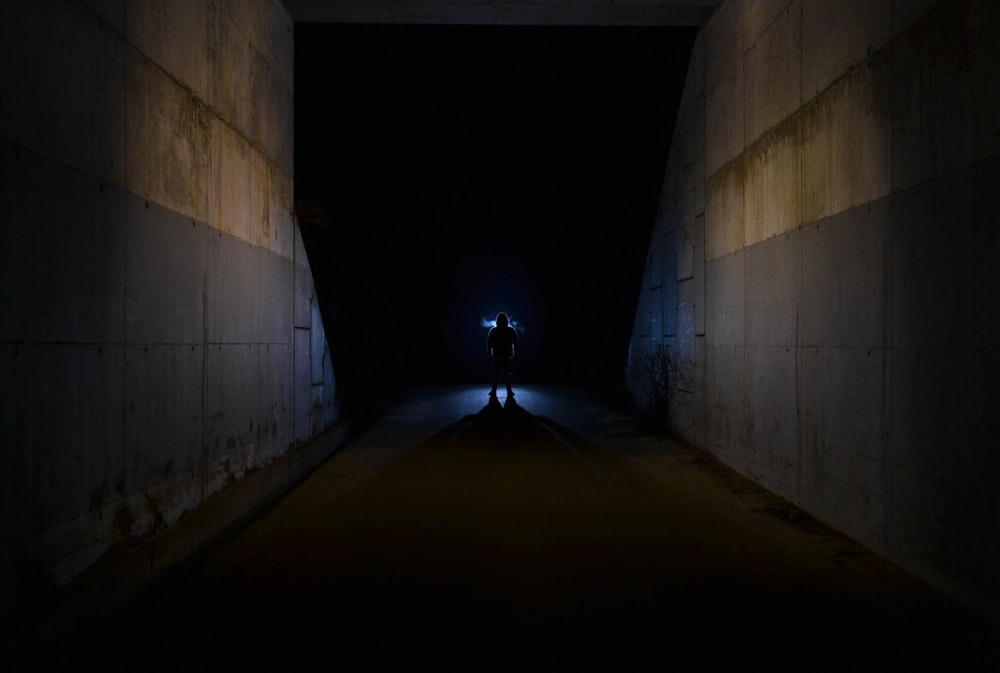 person standing beside gray wall