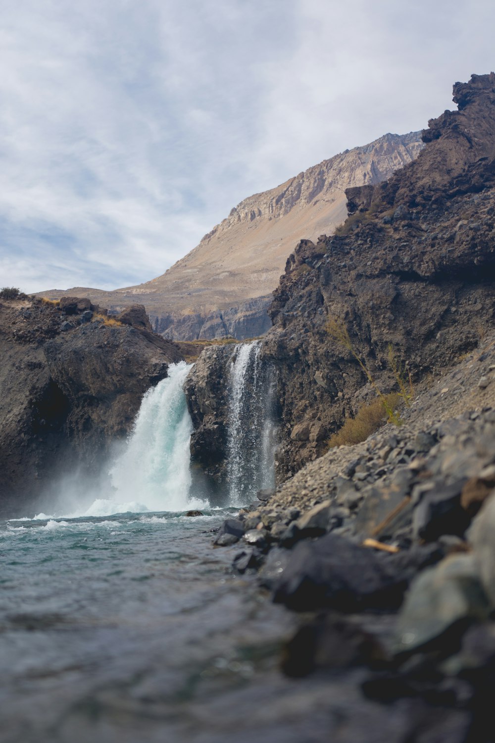 waterfalls under white cloudy sky during daytime