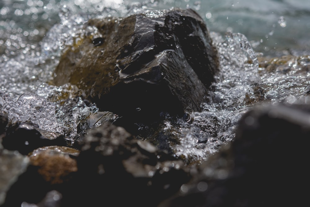 closeup photography of water crashing on stone