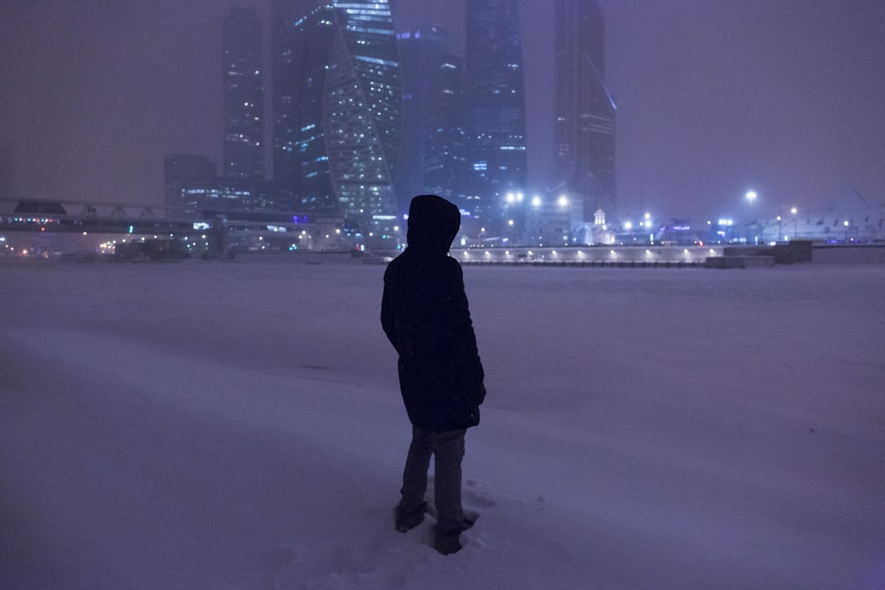person standing on snow during night time
