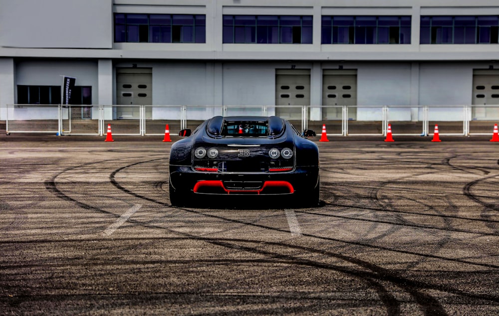 black sports car on park in front of white building