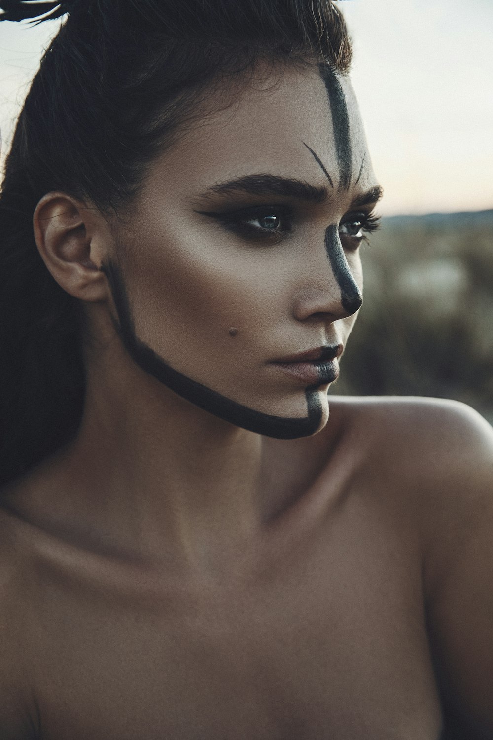 woman standing with black paint on her face