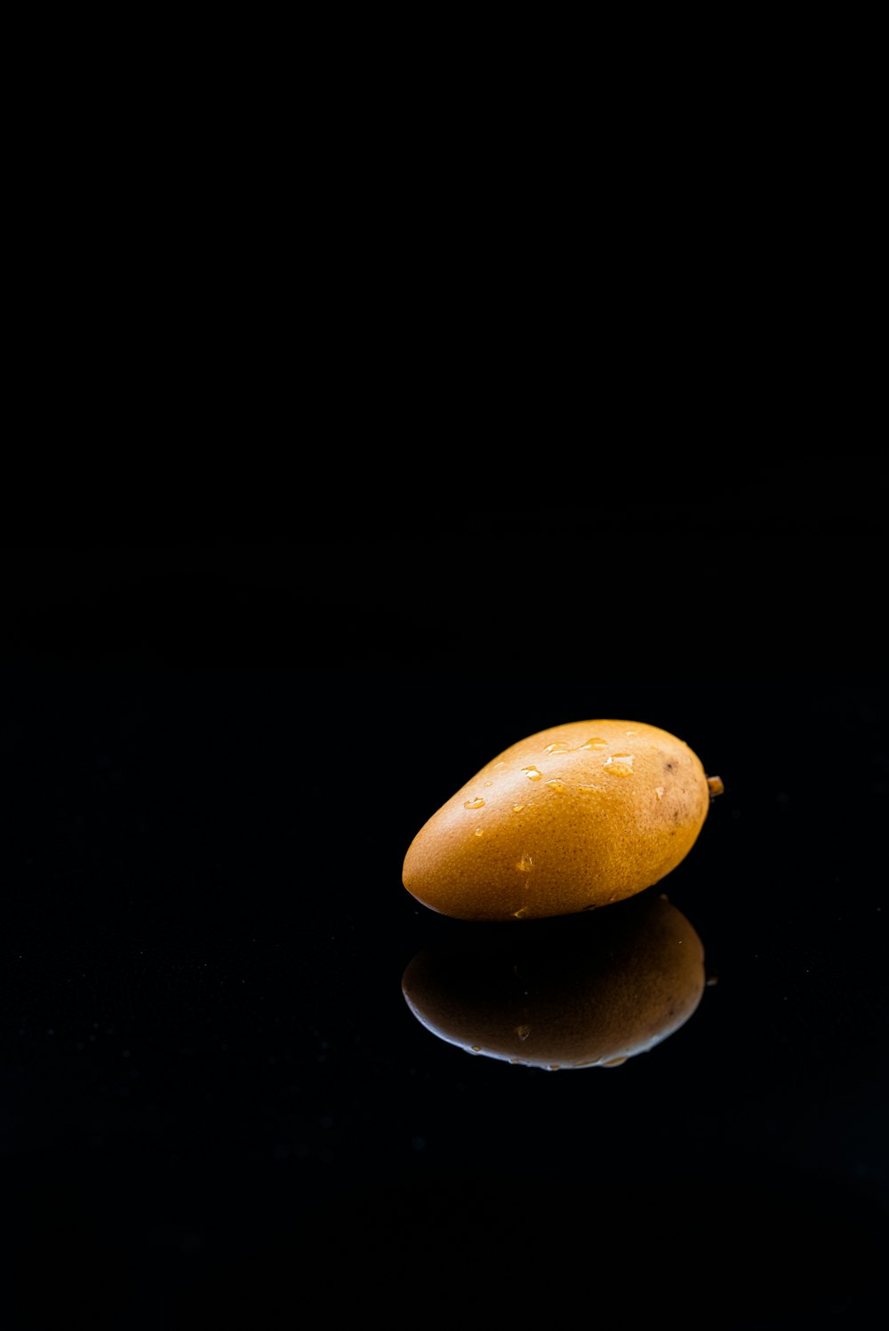 ripe mango reflected on black surface