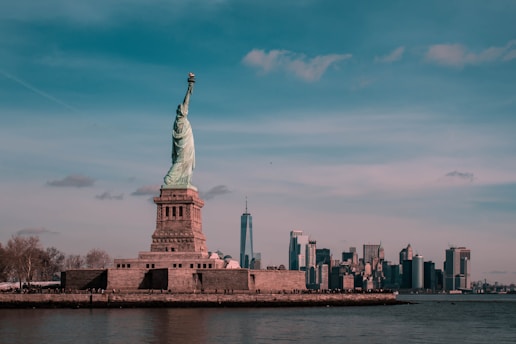 A vibrant cityscape of New York with the Statue of Liberty in the foreground.